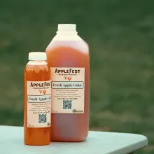 2 AppleFest branded bottles of apple cider.