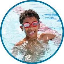 Child smiling in a swimming pool. 