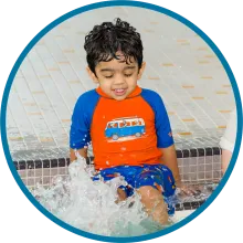 Child kicks water pool side