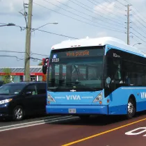 A car and a Viva bus on the road.