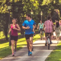 Outdoor trail filled with people walking, jogging, and cycling.