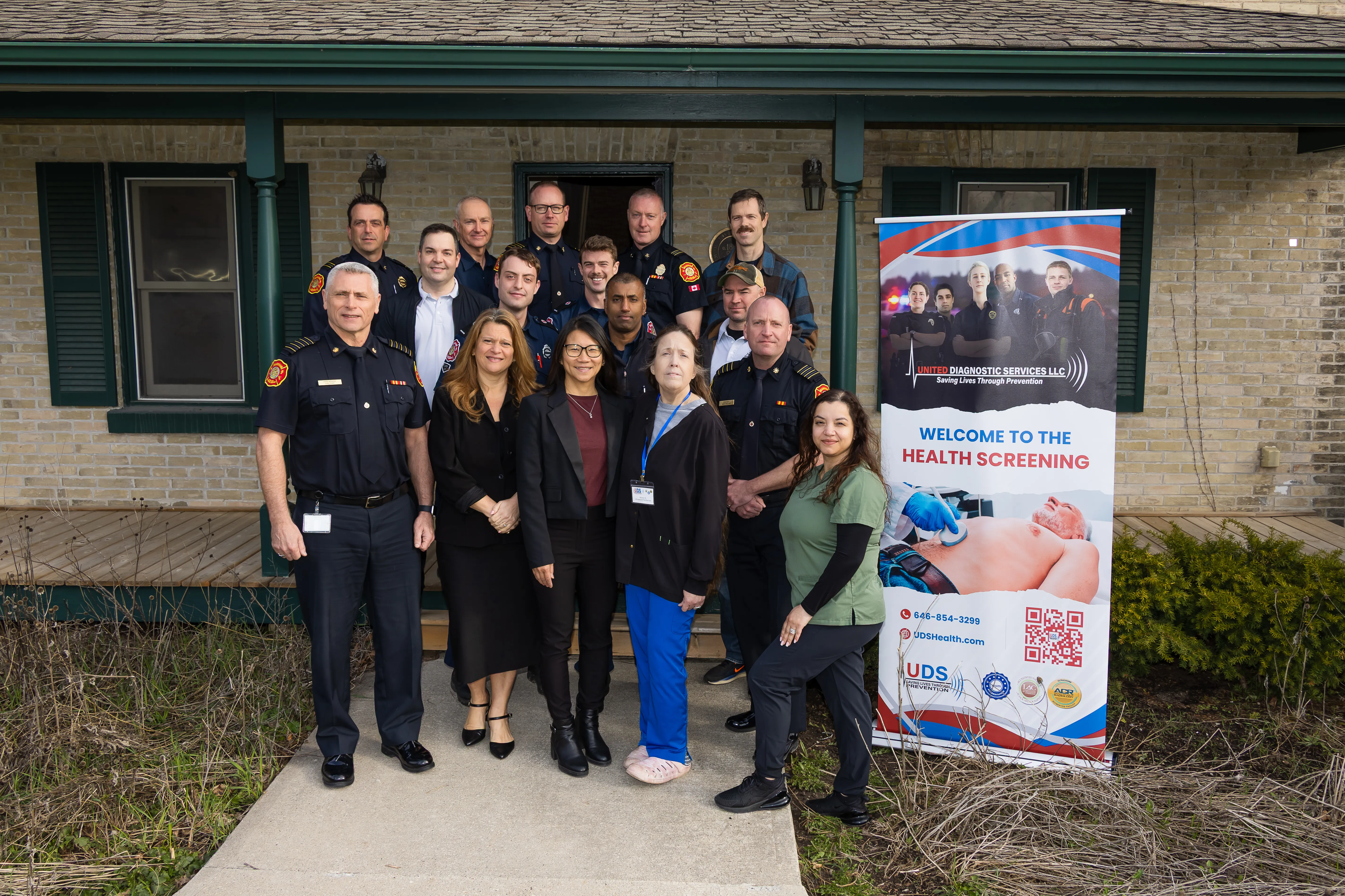 City staff and Markham Firefighters pose in front of the new On-Site Health Screening Program banner