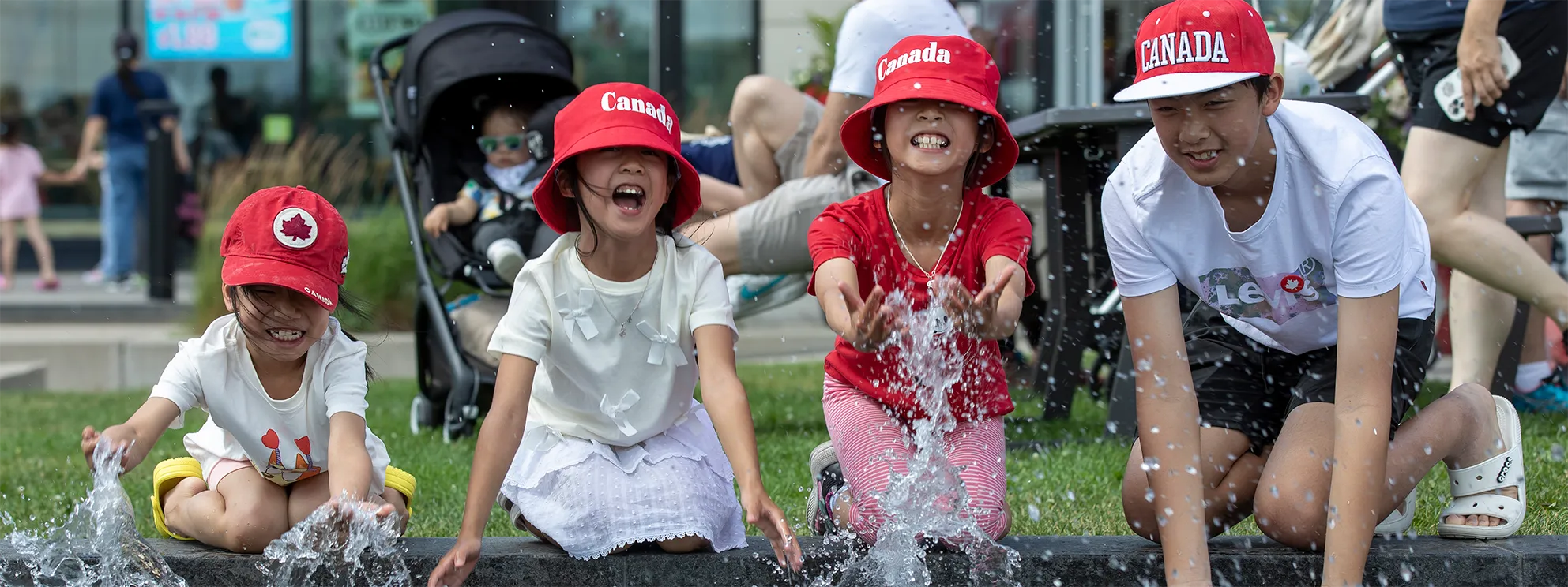 Children smiling while splashing in fountain.