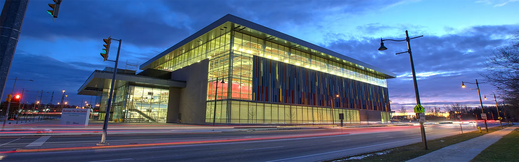 Exterior of Pan Am facility at night with car lights streaks.